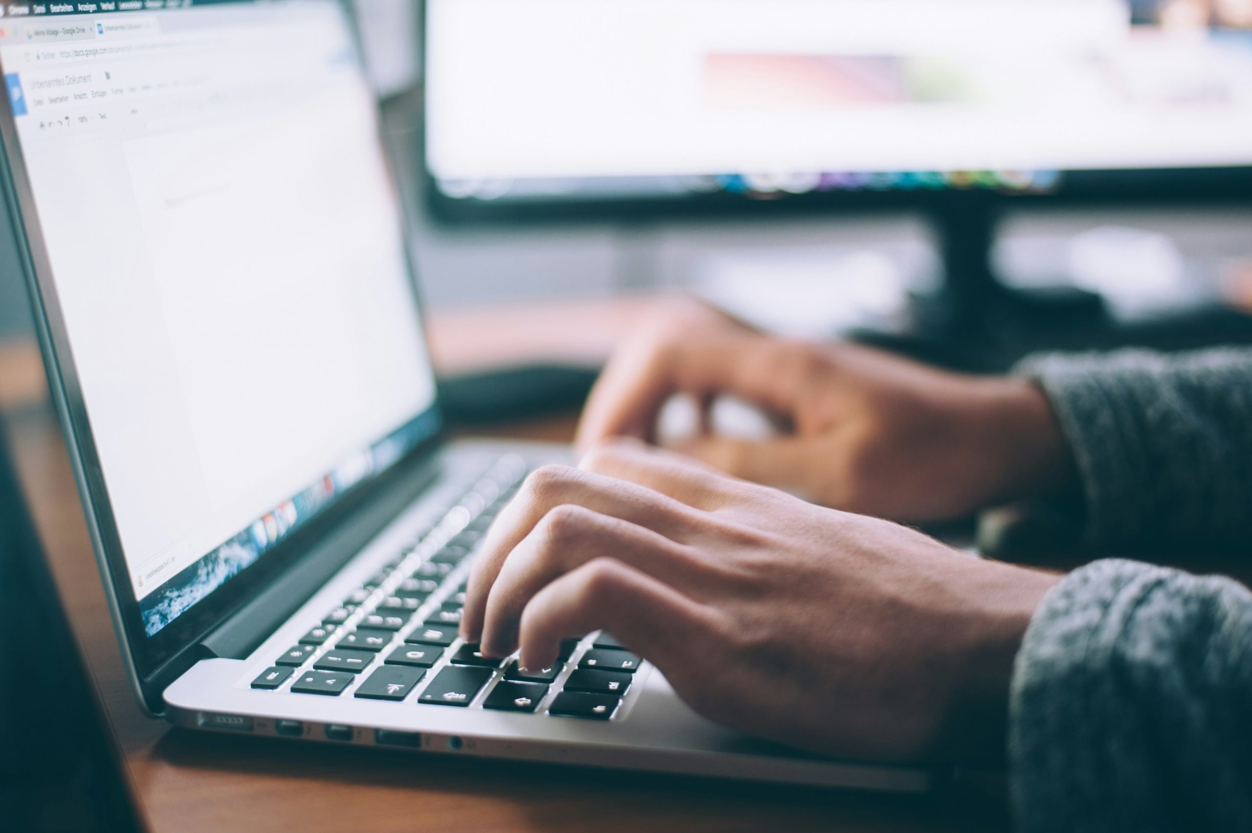 Close up of someone's hands typing on a laptop keyboard